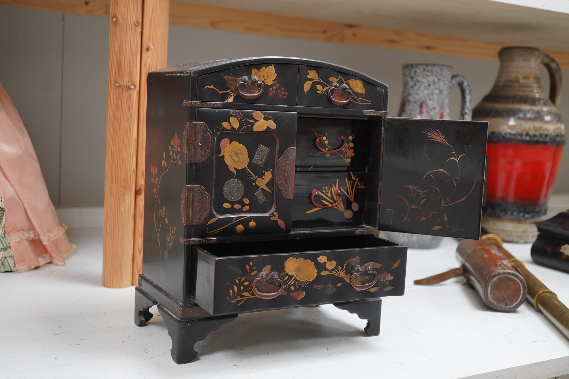 A late 19th early 20th century Japanese lacquer cabinet, 31cm high. Condition - exterior chipped and cracked near the top edge